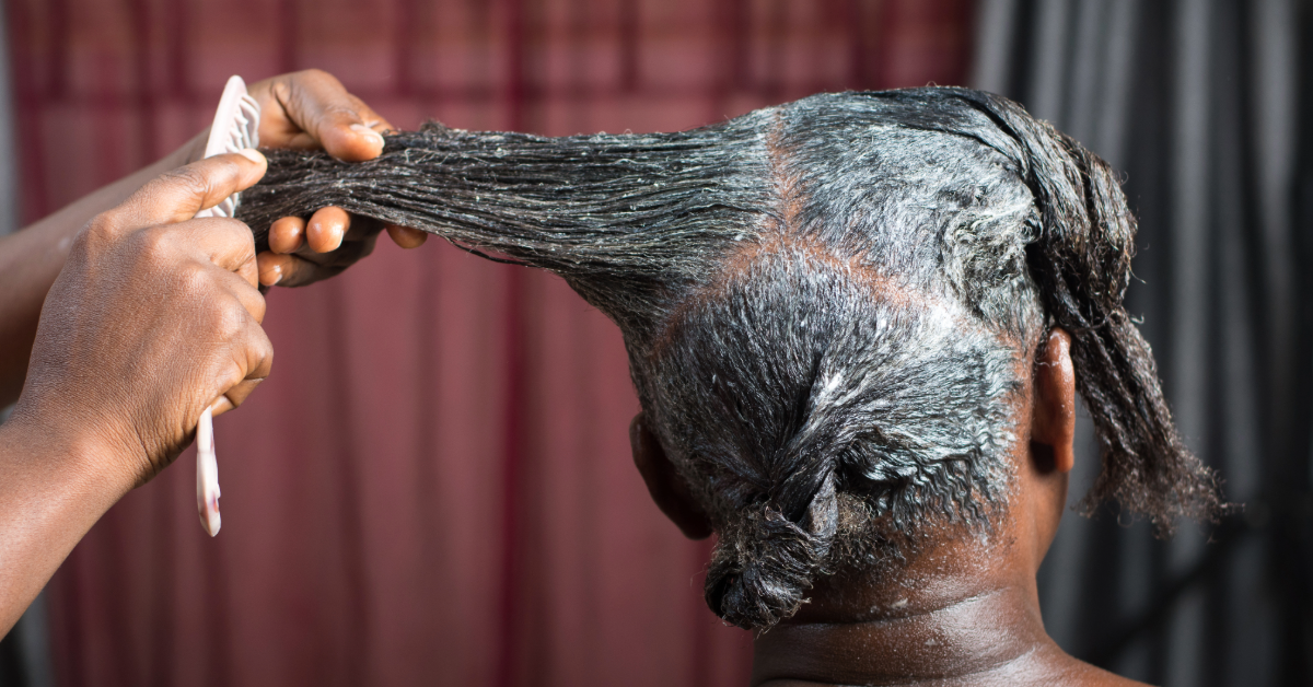 Featured image of a black woman receiving a hair relaxer treatment