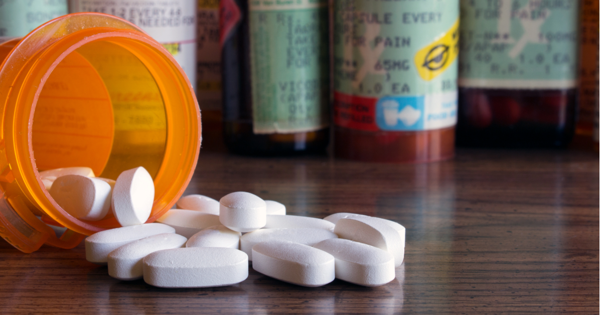 Spilled bottle of white pills on wooden table